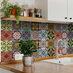 a kitchen with colorful tiles on the backsplash and wooden counter tops, potted plant next to sink