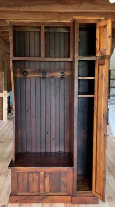 an old wooden entertainment center with sliding doors and shelves on the sides, in a room that has wood flooring