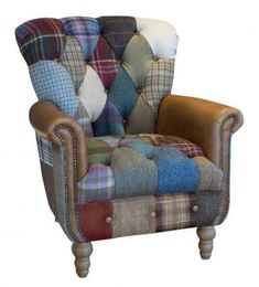 a plaid chair with leather trim and buttons on the back, sitting in front of a white background