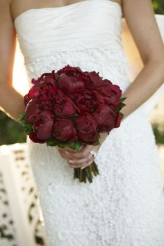 a woman in a white dress holding a bouquet of flowers