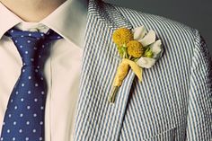 a man wearing a suit and tie with a boutonniere on his lapel