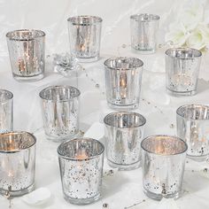 many silver colored glass cups on a white table