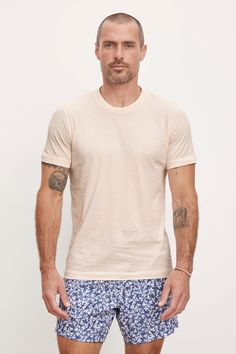 A man with tattoos on his arms wearing a Velvet by Graham & Spencer RANDY CREW NECK TEE and patterned blue shorts against a plain background. Velvet Tees, Cami Shirt, Linen Shop, Nassau, Sweater Sale, Crew Neck Shirt, Crew Neck Top, Mens Crew Neck, Jacket Sale