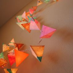 several colorful kites are hanging from the ceiling