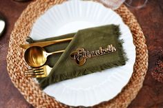 a place setting with napkin, fork and knife on a woven table cloth that says elizabeth