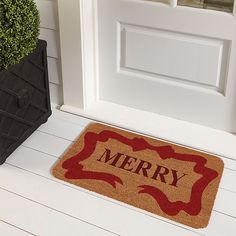 a door mat with the word merry on it next to a potted plant in front of a door