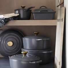 pots and pans are sitting on shelves in the kitchen, with one being used for cooking