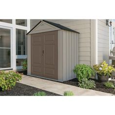 a brown shed sitting next to a white house