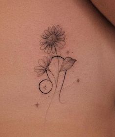 a woman's back with a flower tattoo on it