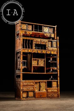 an old wooden bookcase with drawers and clocks on the front, against a black background