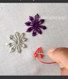 someone is stitching together small crochet snowflakes on a piece of fabric