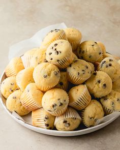 a white bowl filled with muffins on top of a table