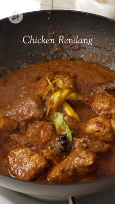 chicken rendang with onions in a pan on the stove