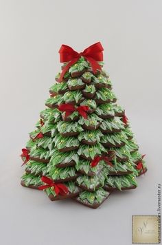 a christmas tree made out of cookies with red bows on the top and green leaves