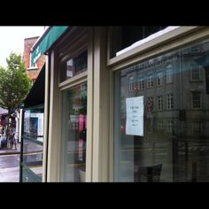 a store front with an open window on the street