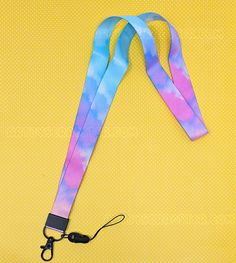 a tie dye lanyard on a yellow background with a camera strap attached to it