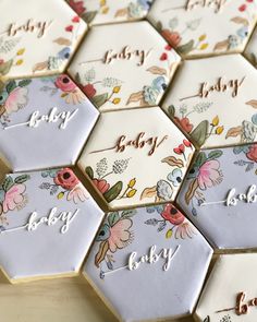 baby shower cookies decorated with flowers and the word baby written on them in cursive writing