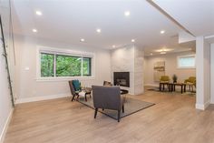 a living room filled with furniture and a fire place next to a dining room table