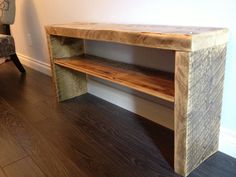 a wooden shelf sitting on top of a hard wood floor next to a chair and wall