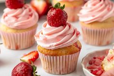 cupcakes with pink frosting and strawberries on top