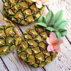 three small pineapples decorated with flowers and leaves