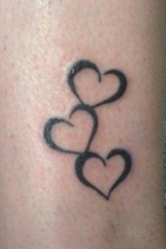 two hearts tattoo on the back of a woman's leg, with black ink