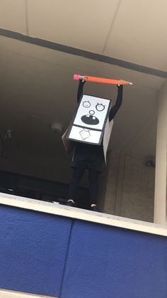 a person holding up a cardboard box with an object on it