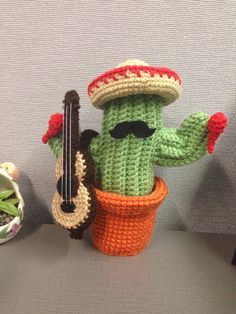 a crocheted cactus with a guitar in it's mouth and wearing a sombrero