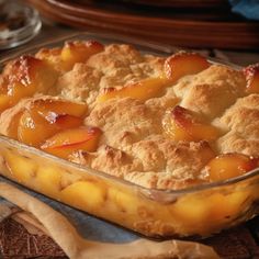 a peach cobbler in a glass dish on a table