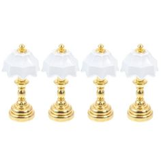 four gold and white candlesticks on a white background