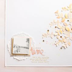 a white card with gold foiling and some paper flowers on the front, along with an envelope that says time