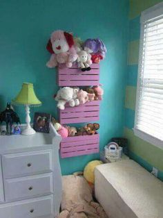 a bedroom with blue walls and pink shelves filled with stuffed animals on top of them