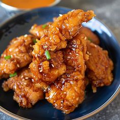 a blue plate topped with fried chicken on top of a table