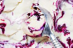 a scoop of ice cream sitting on top of a white plate covered in blueberries