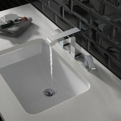 a white sink sitting under a faucet next to a counter top with soap