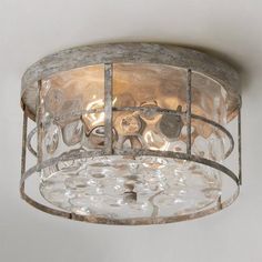 a glass and metal light fixture hanging from the ceiling