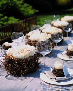 the table is set with wine glasses, plates and desserts in nests on them