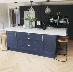 a kitchen with blue cabinets and white counter tops