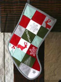 a christmas stocking hanging from the side of a bed with snowflakes on it