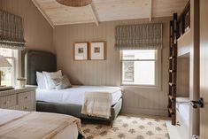 two beds in a room with wooden walls