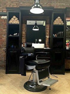 a hair salon with black chairs and brick walls