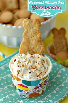 a cup filled with whipped cream next to cookies