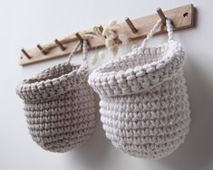 two crocheted baskets hanging on a wall