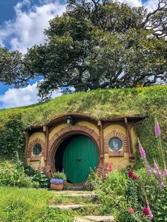 the hobbot house is surrounded by flowers and trees