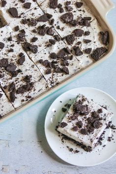 a pan filled with cake next to a plate full of cookies and cream cheesecakes