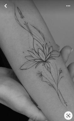 a woman's arm with a flower tattoo on it