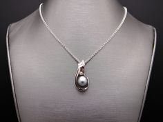 Estate 14kt White Gold Genuine Black Tahitian South Sea 11mm Pearl & .05ct Diamond Pendant. Set into this wonderful, 1 inch by 1/2 inch, pendant is 1 Fine Quality Black Tahitian South Sea Pearl which measures 11mm. The Pearl is black/gray with strong luster and nacre thickness and very few blemishes. Also set is 1 fine quality Round Brilliant Cut Diamonds H color, SI-1 clarity weighing 0.05cts total approx. This beautiful Estate 14kt White Gold 11mm Black South Sea Pearl & Diamond Pendan White Gold Tahitian Pearl Jewelry For Anniversary, Fine Jewelry Tahitian Pearl Necklace For Anniversary, Tahitian Pearl Fine Jewelry Necklace For Anniversary, Tahitian Pearl Necklace For Anniversary, Tahitian Pearl Round Pendant Necklace For Anniversary, Silver Tahitian Pearl Necklace Fine Jewelry, Silver Tahitian Pearl Necklace, Tahitian Pearl Pendant Necklaces For Formal Occasions, Formal Tahitian Pearl Pendant Necklaces