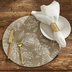 a place setting on a wooden table with napkins and gold forks, knife and fork