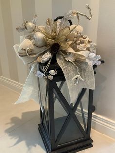 a lantern with flowers and ribbons on it