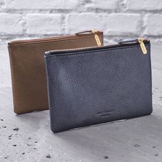 two leather wallets sitting next to each other